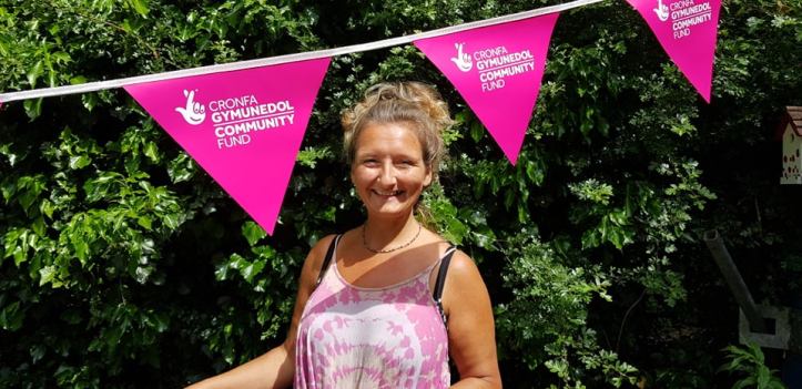 A woman standing in front of The National Lottery Community Fund bunting