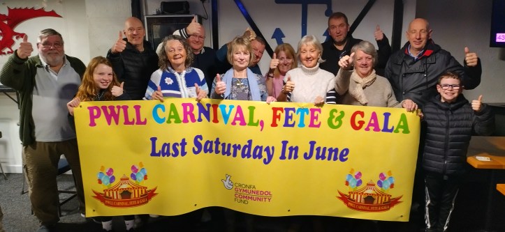 A group of people celebrating in front of a banner